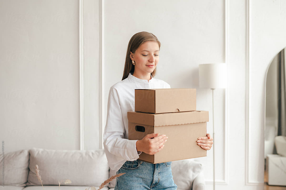 Calm woman with carton boxes in living room