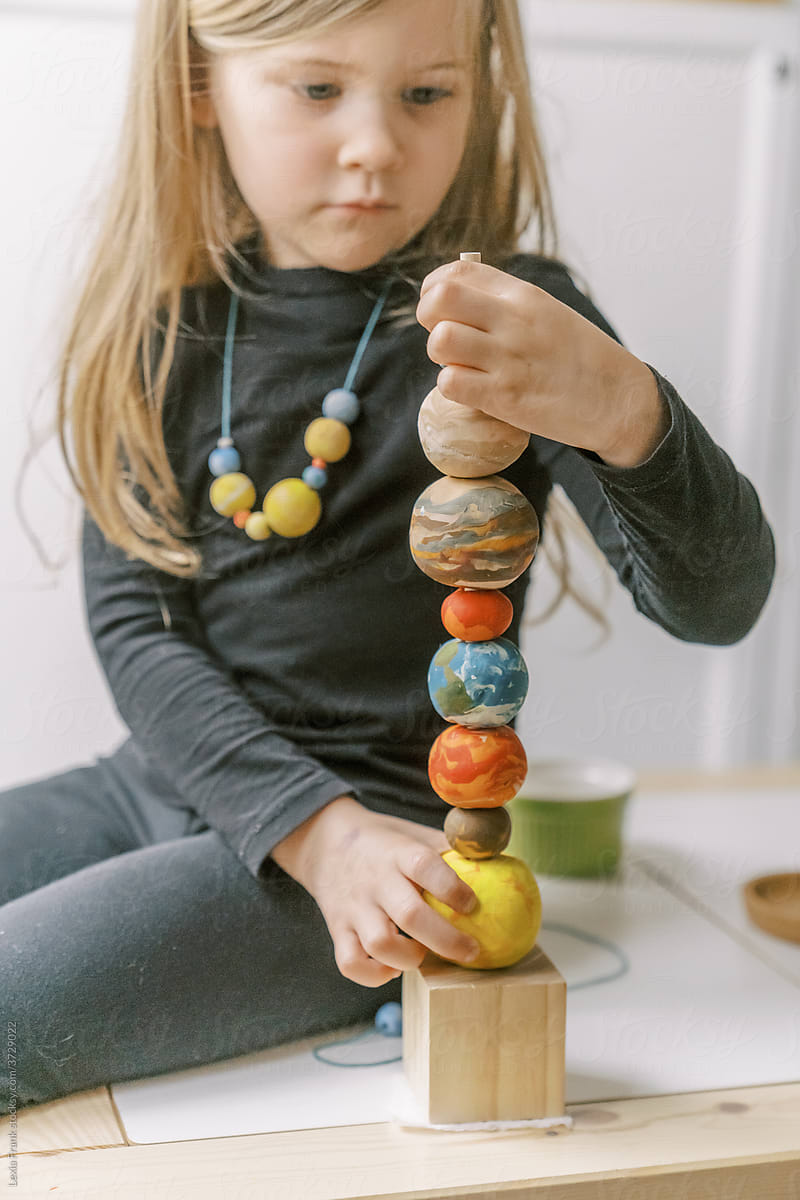 little girl plays with planet stacking toy 6
