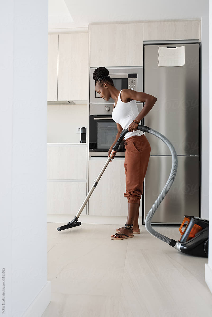 African woman doing housework routine in kitchen