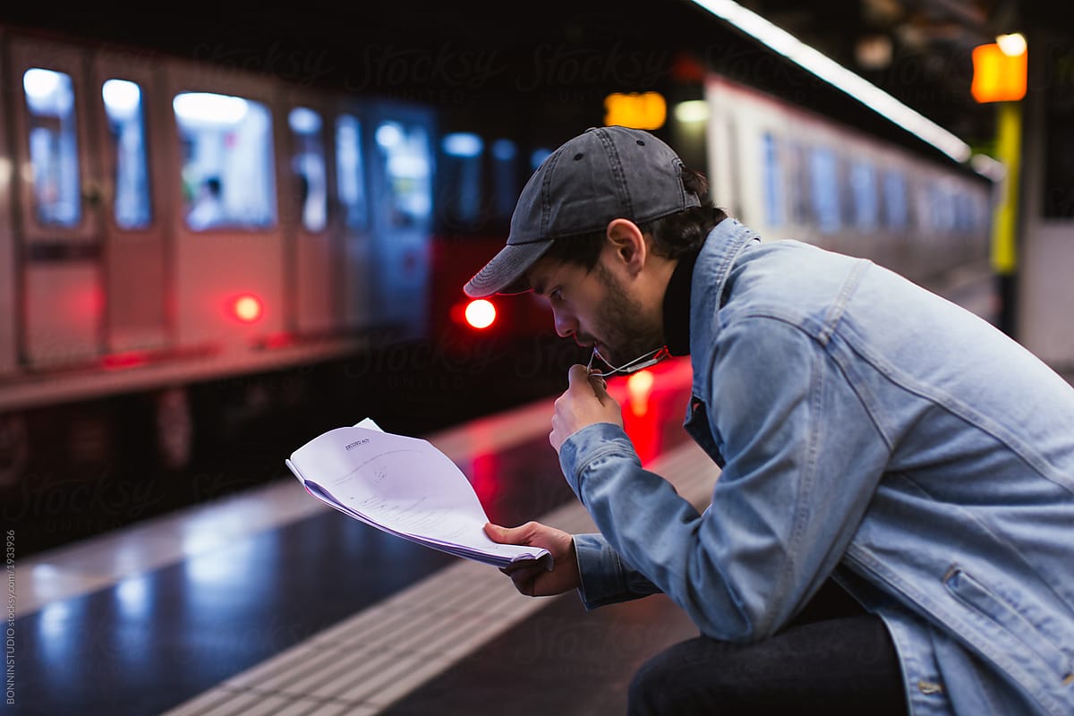 Actor reading script in subway station.