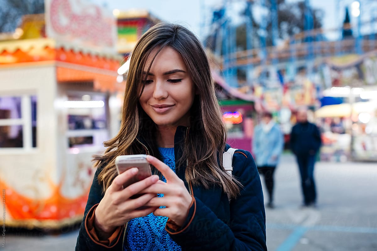 Woman using a mobile phone in an amusement park