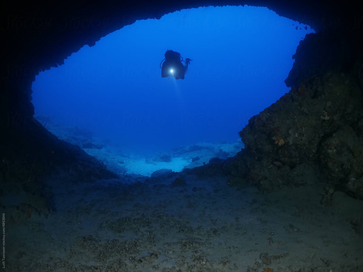 cave diving underwater scuba divers exploring caves ocean scenery