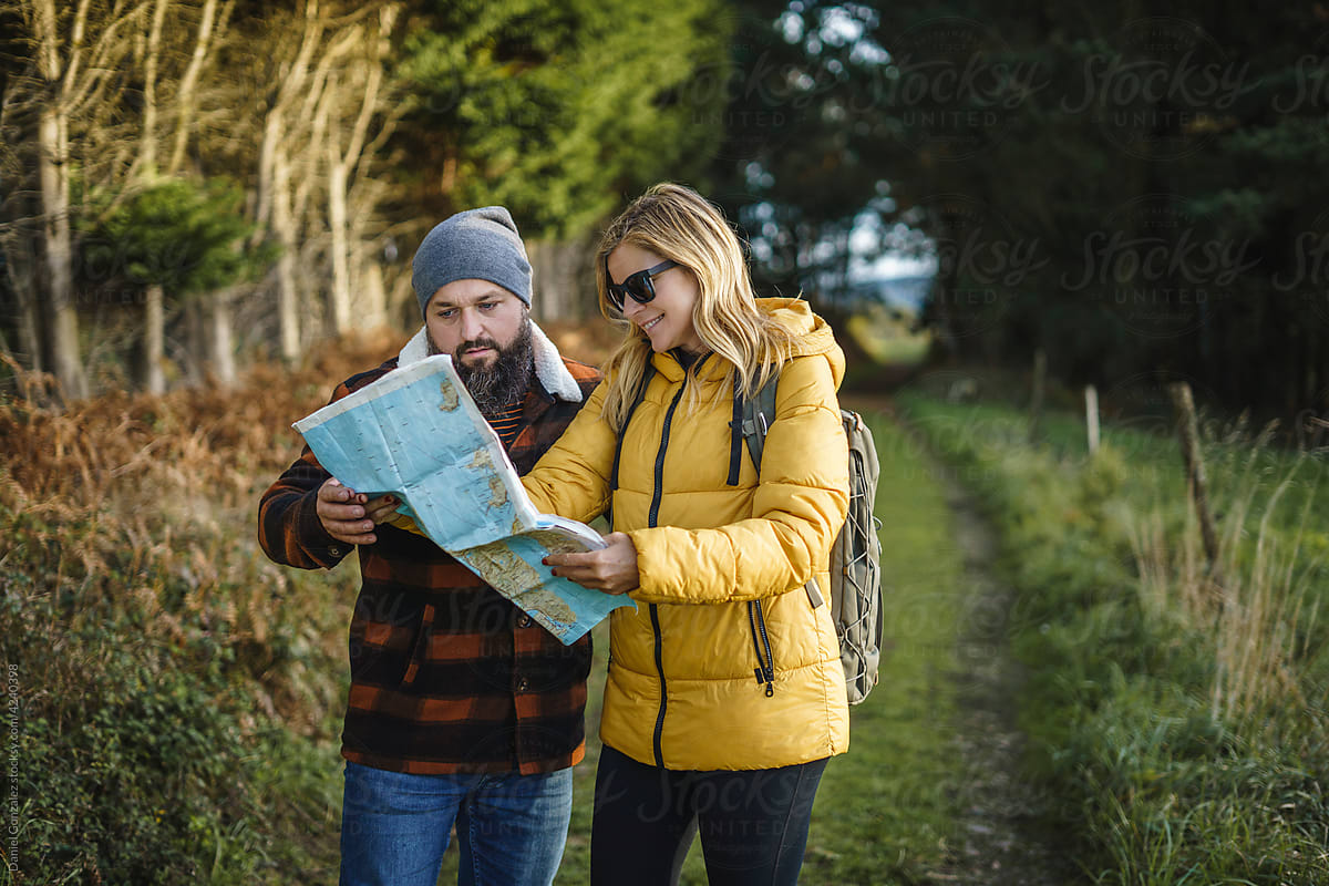 Traveling couple orientating with paper map