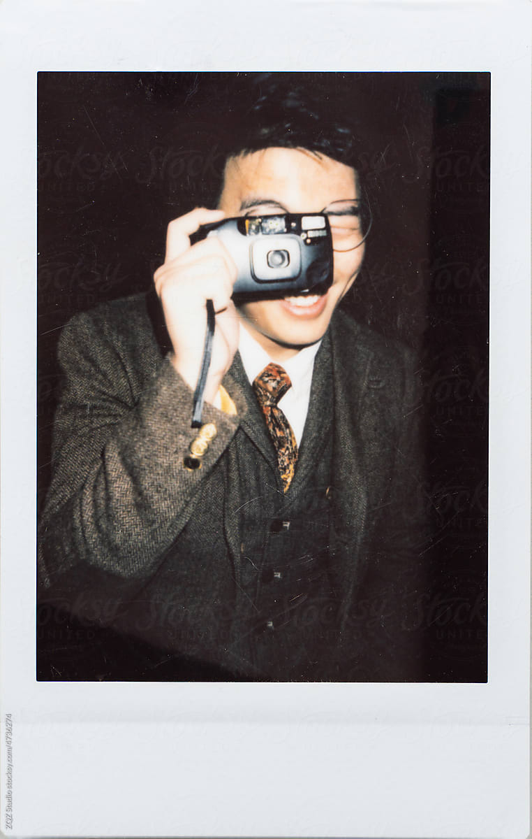 Polaroid photo of young man holding a camera