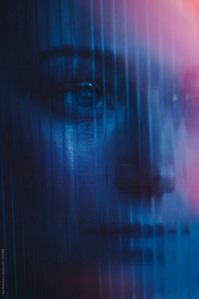 Woman through textured glass in dark neon