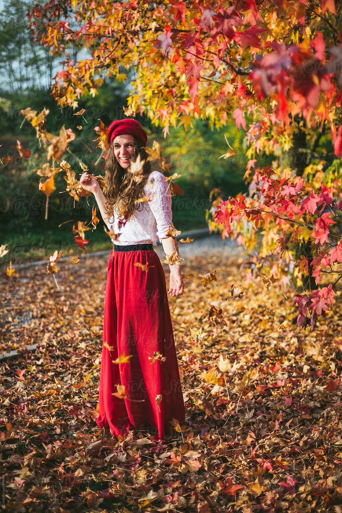 Young woman dressed in red enjoying the fall season in a forest