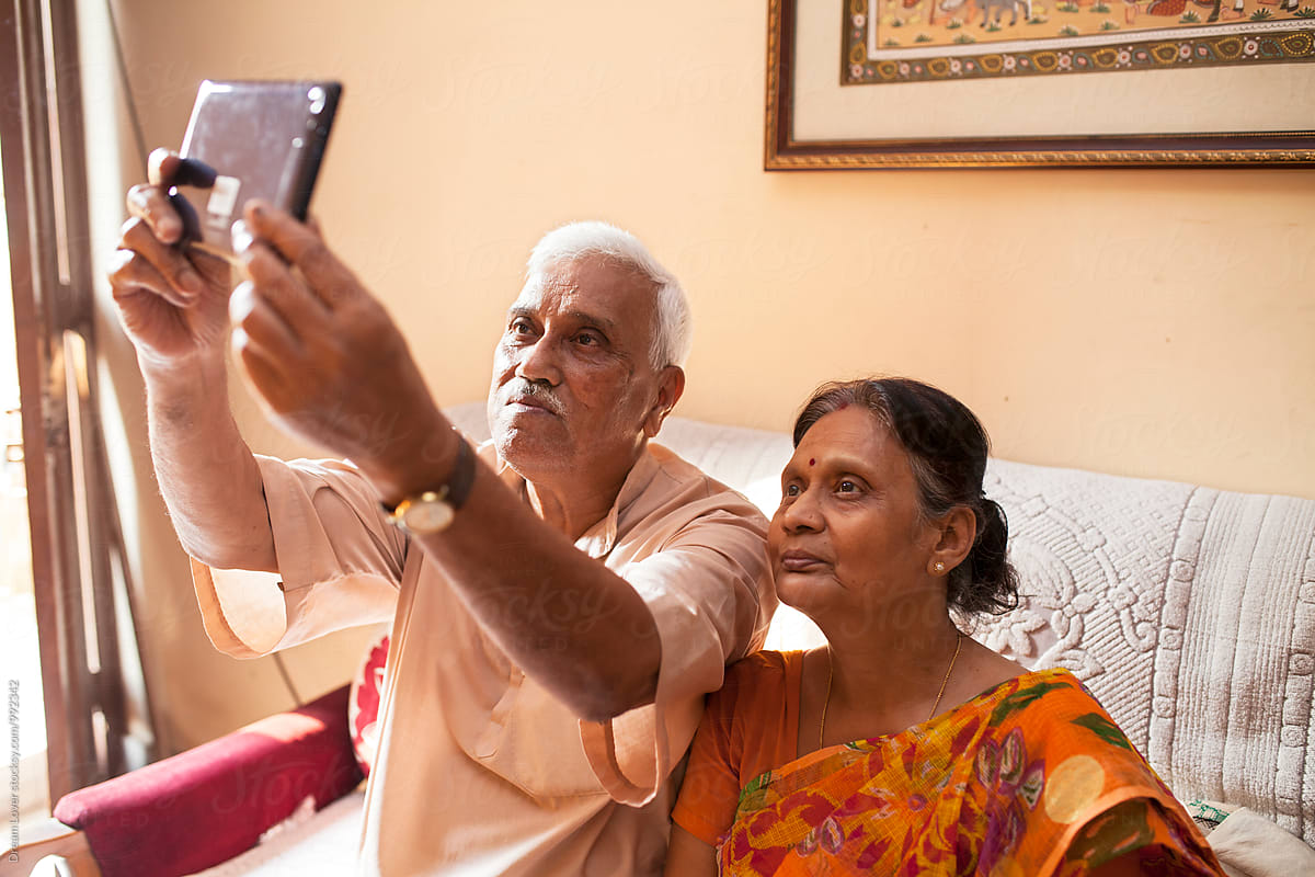 Aged Indian couple taking photograph with a Tablet