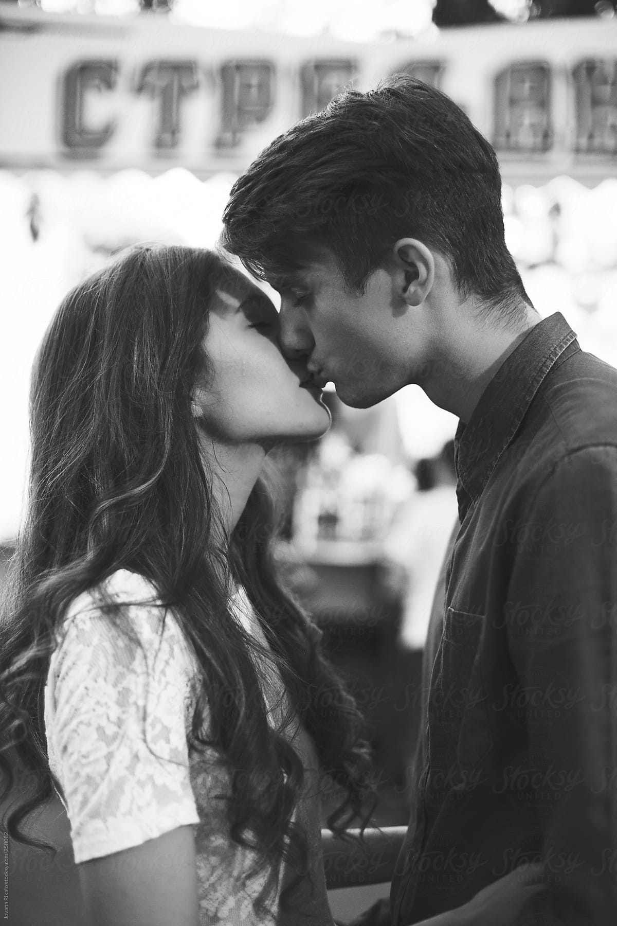 Young couple kissing at the carnival