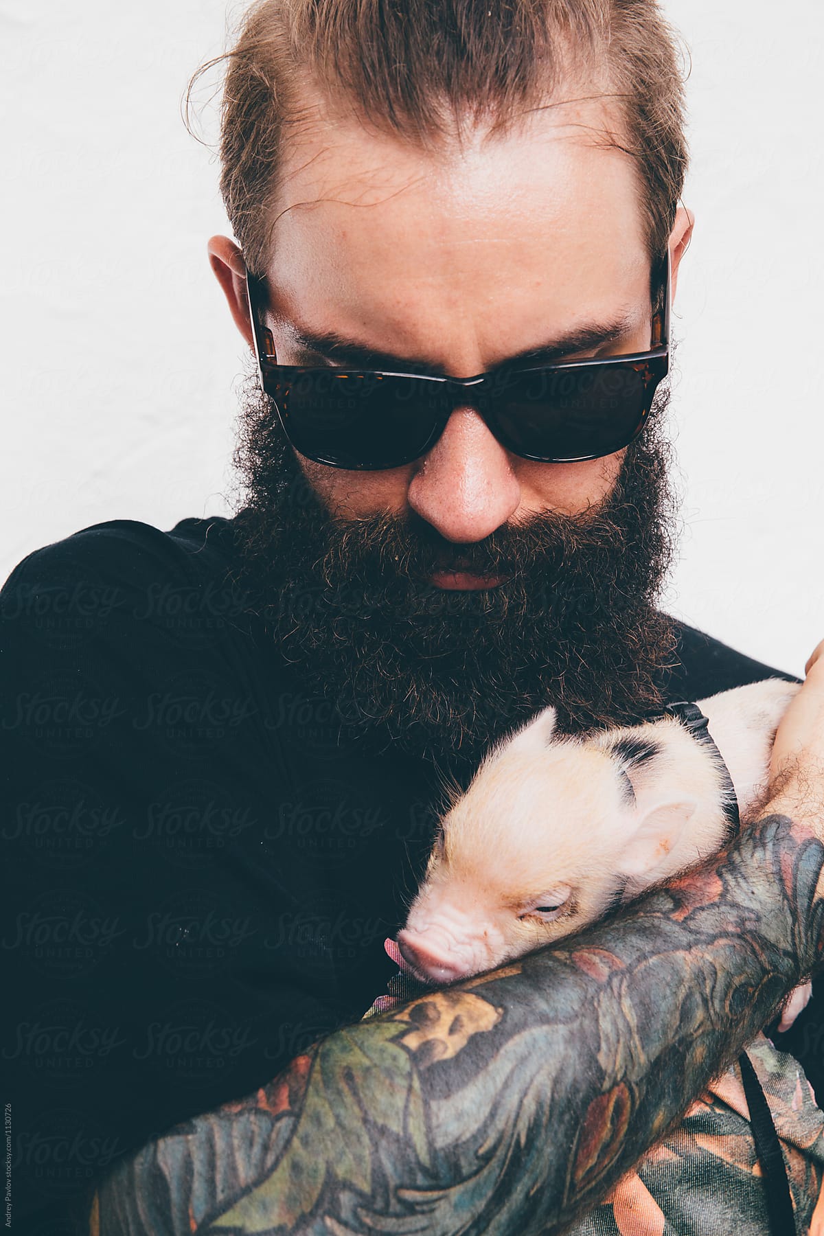 brutal man with piglet in hand