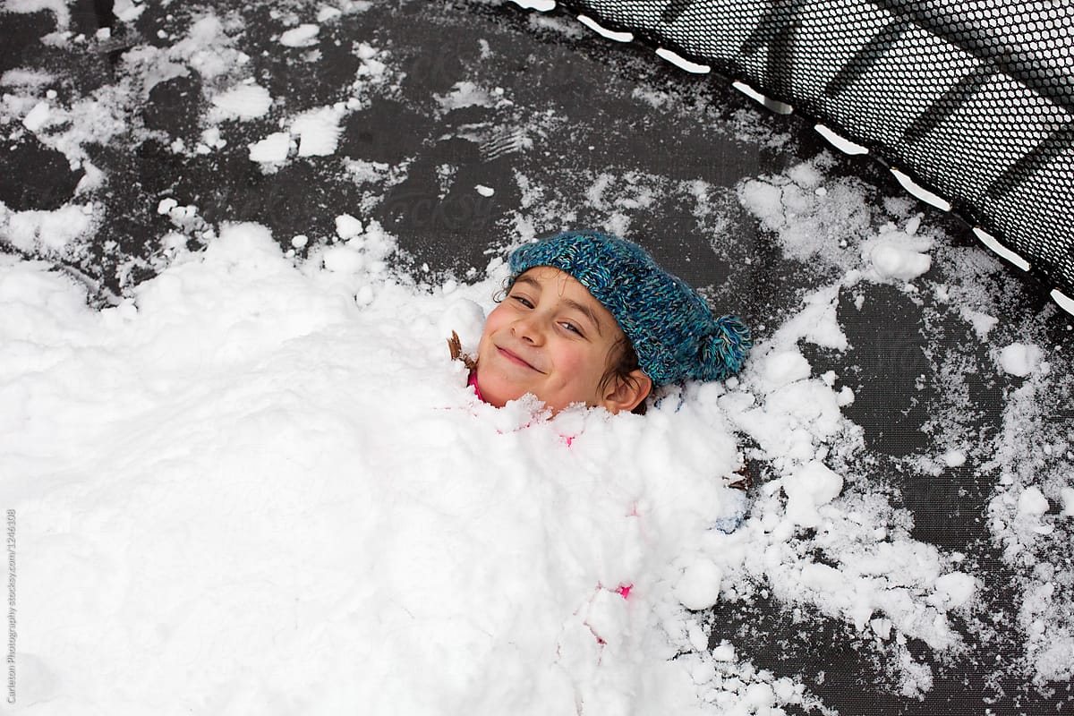 Ten Year Old Girl Is Buried In Snow Up To Her Chin" by Stocksy Contributor  "Carleton Photography" - Stocksy