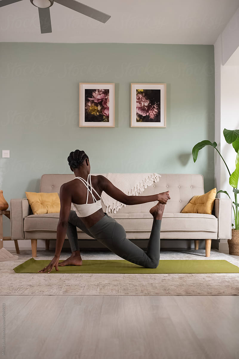 Black woman doing Crooked Monkey yoga pose