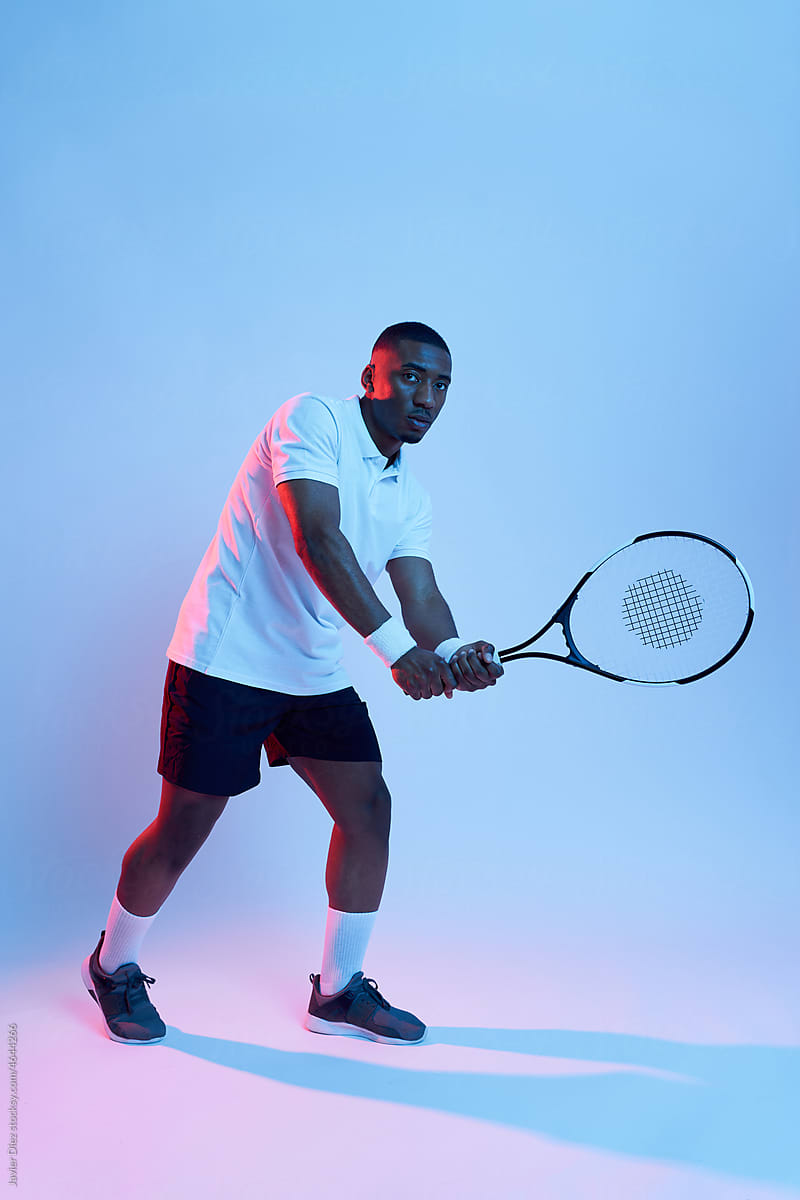 Male tennis player swinging racket