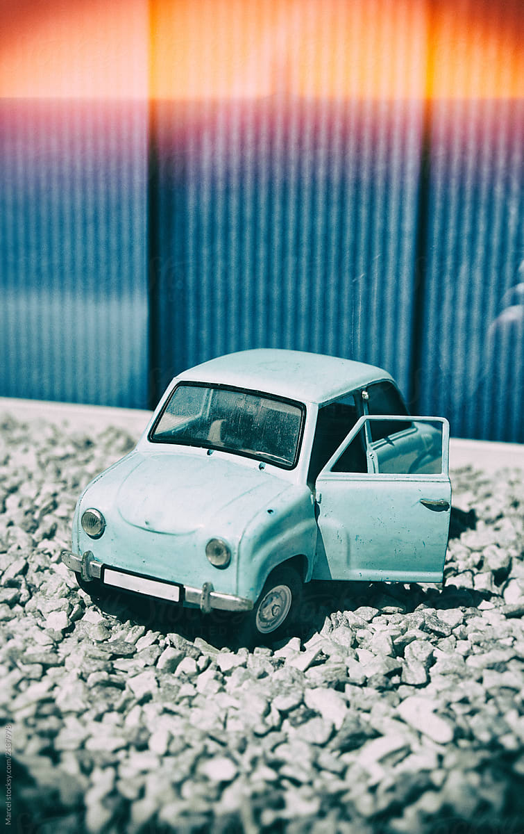 Old toy car on pebbles