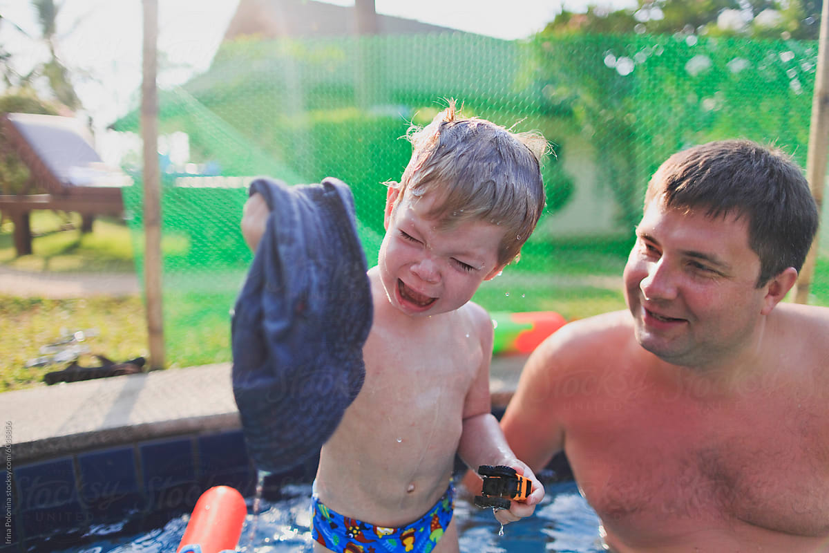 Father and son spend time in the pool in the summer