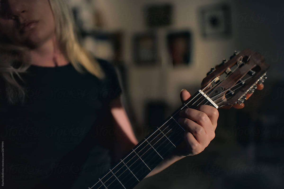 A beautiful woman plays the guitar