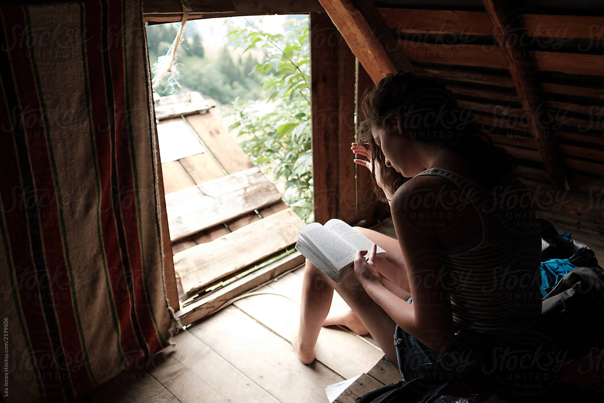 teen reading in a rustic mountain hut in the French Alps