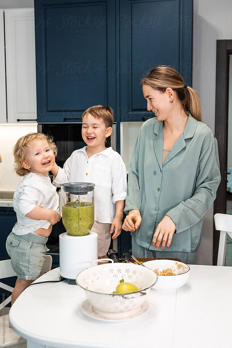 A woman and her kids are making smoothies