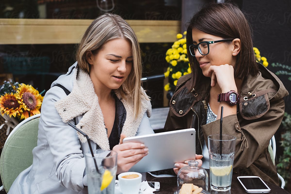 Two Female Friends Using Tablet Computer at a Cafe