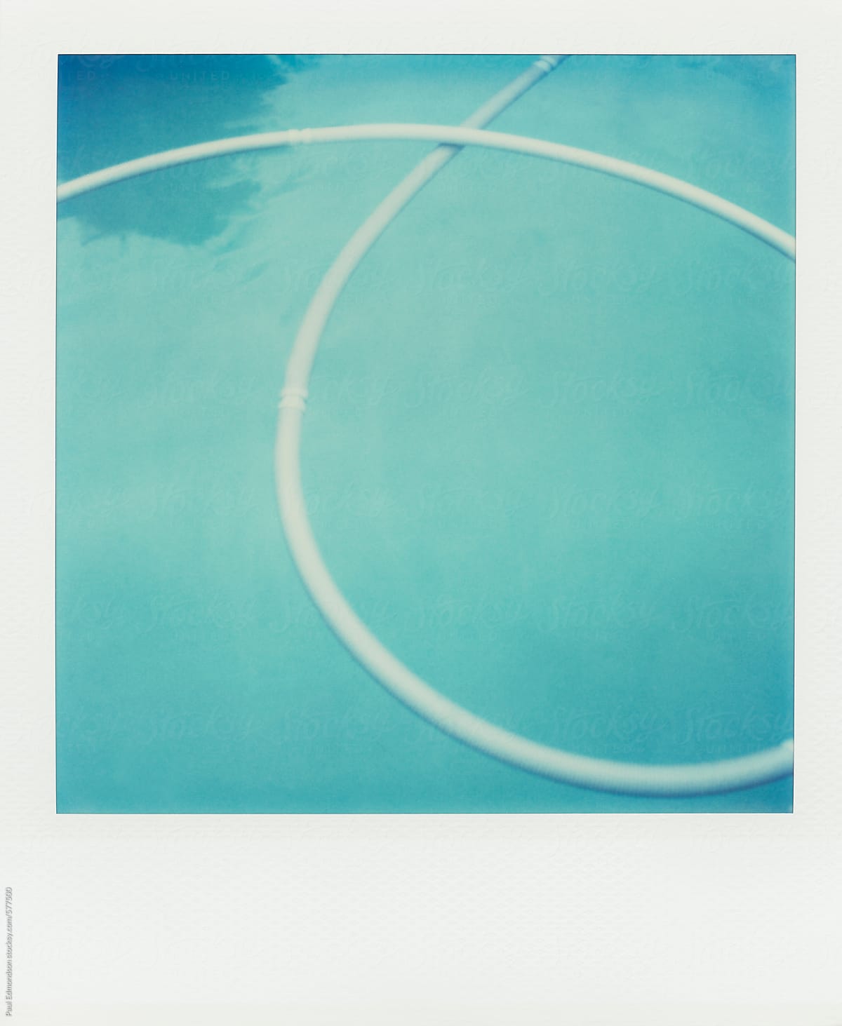Plastic tubing floating on surface of swimming pool water (Polaroid SX-70 print)