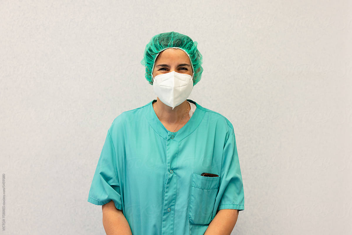 Positive young female doctor in scrubs