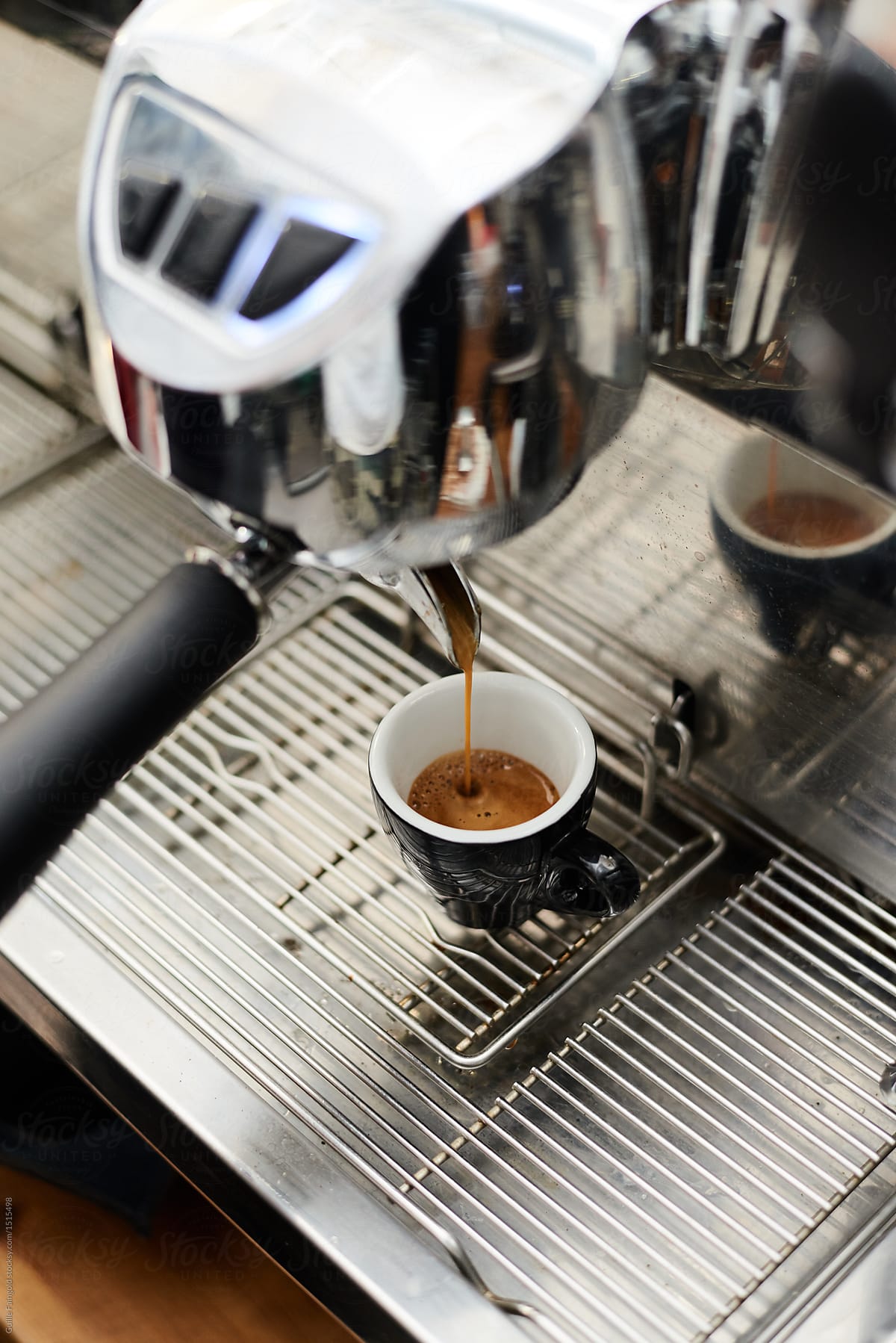 coffee machine producing espresso in tiny cup