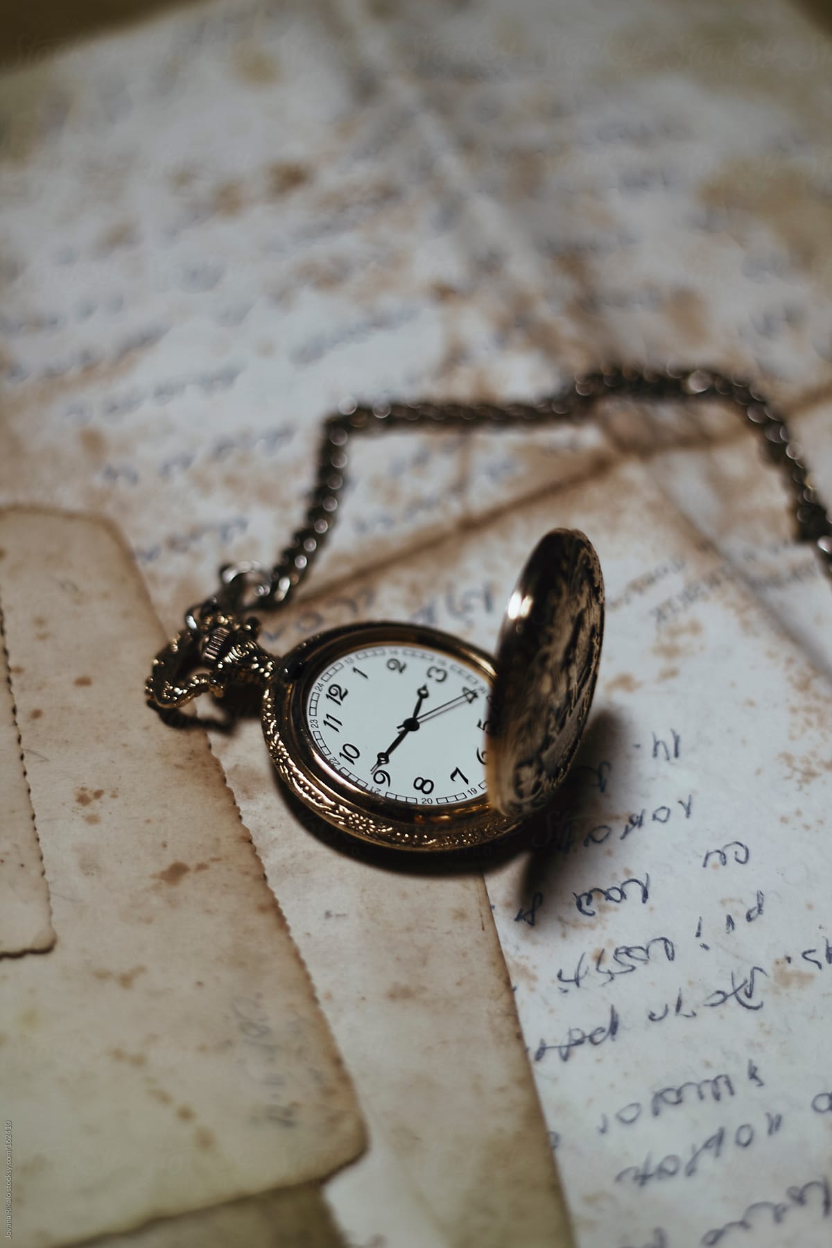 Old watch on an old letters and photographs