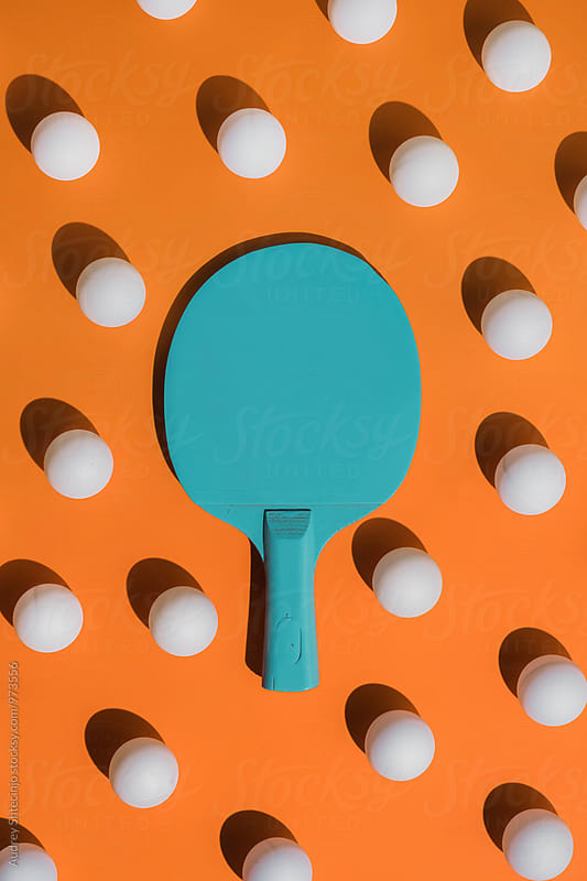 Blue ping pong racket with ball.