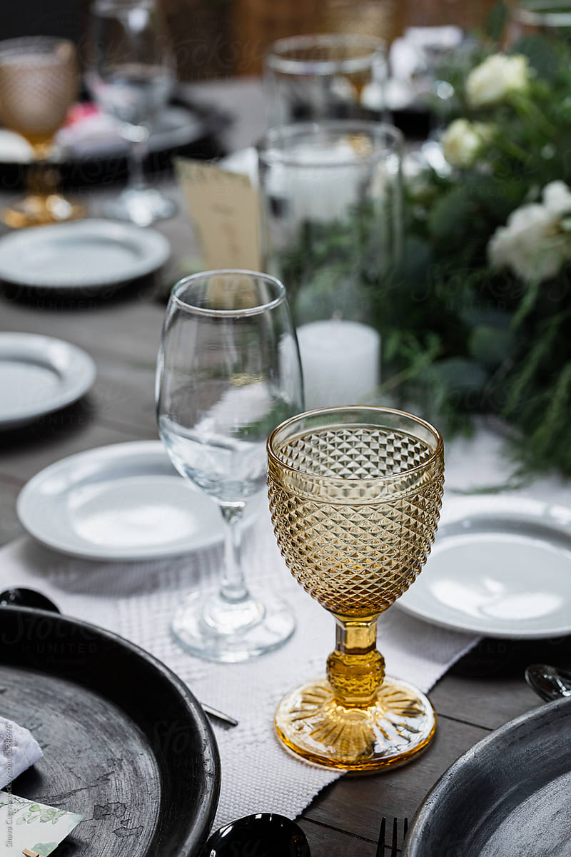 Yellow wine glass on a wooden table at a wedding