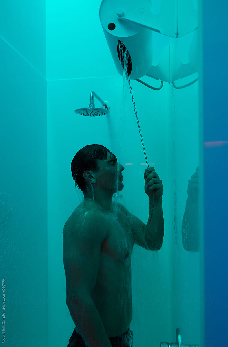 Man showering under blue light aesthetics