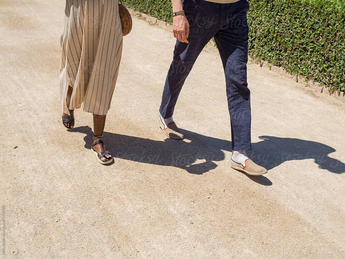 Crop diverse couple walking on summer day