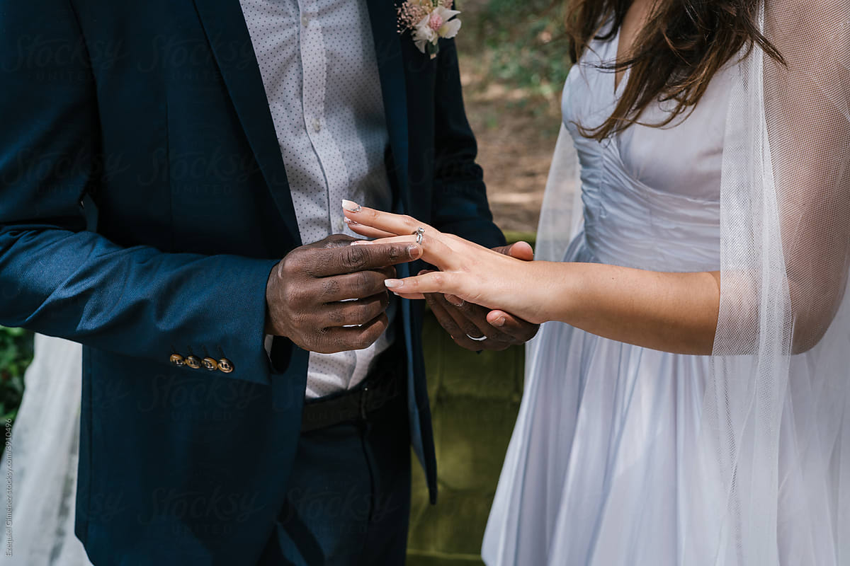Anonymous hands of couple putting on wedding ring