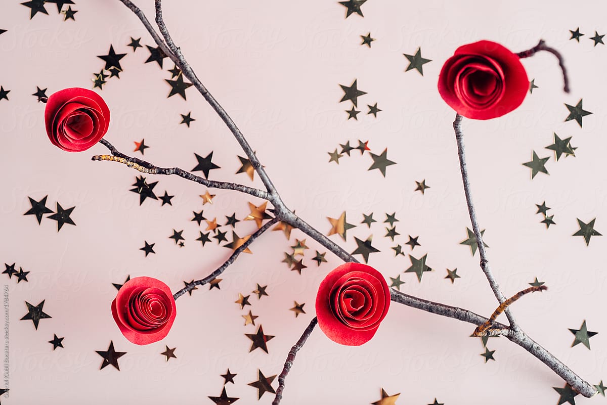 Red paper roses on a tree branch