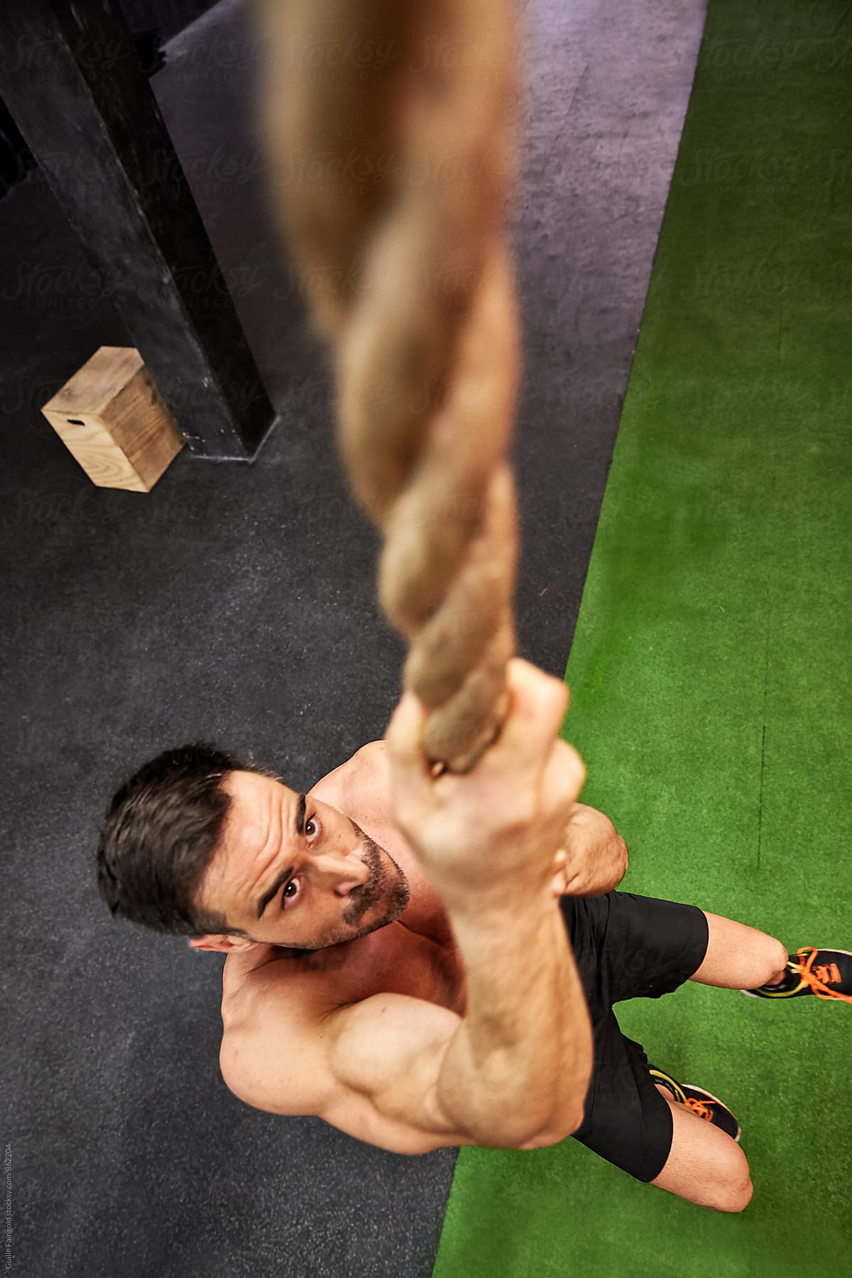 Strong Athlete Climbing A Rope In A Gym By Stocksy Contributor