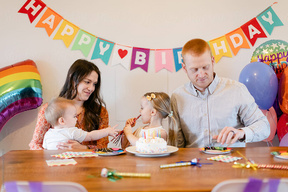 Family Sitting at Table for Child\'s Birthday