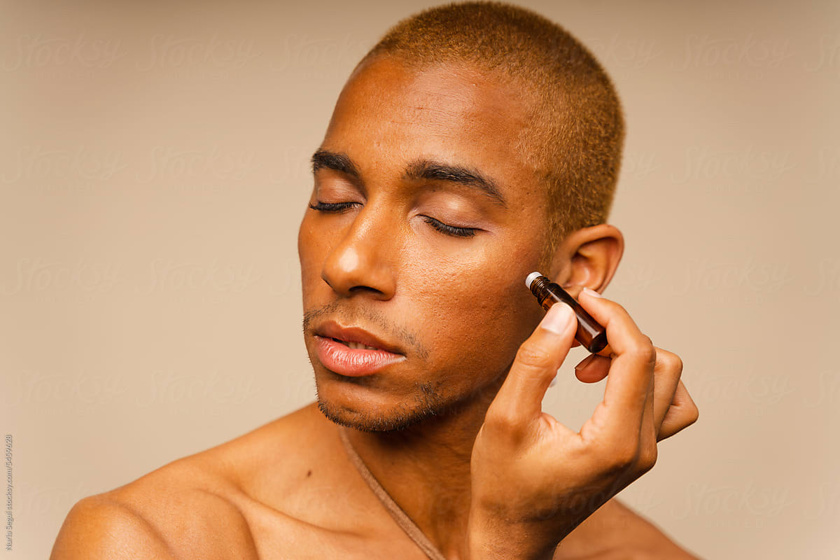 Man Applying Beauty Cosmetic Product During Skin Care Treatment
