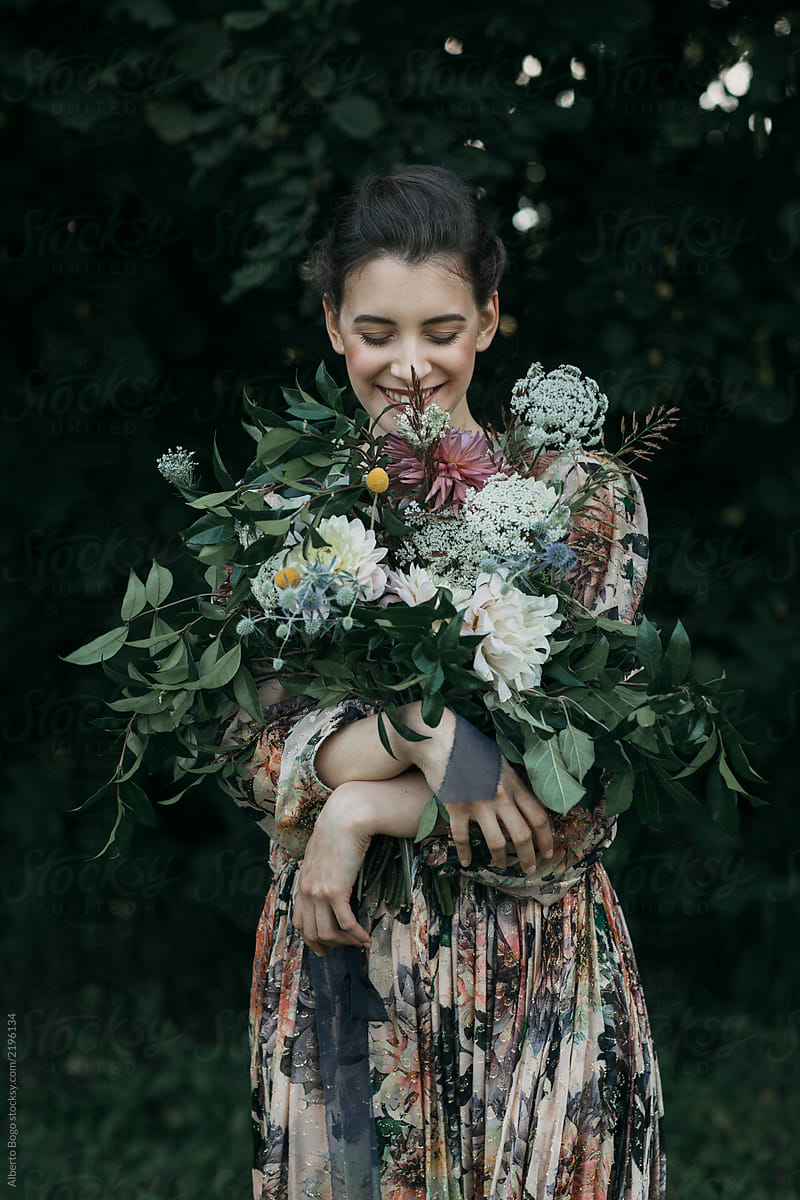 Smiling woman in dress holding rustic bouquet