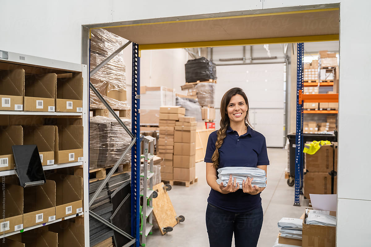 Happy Worker Holding Parcel At Warehouse