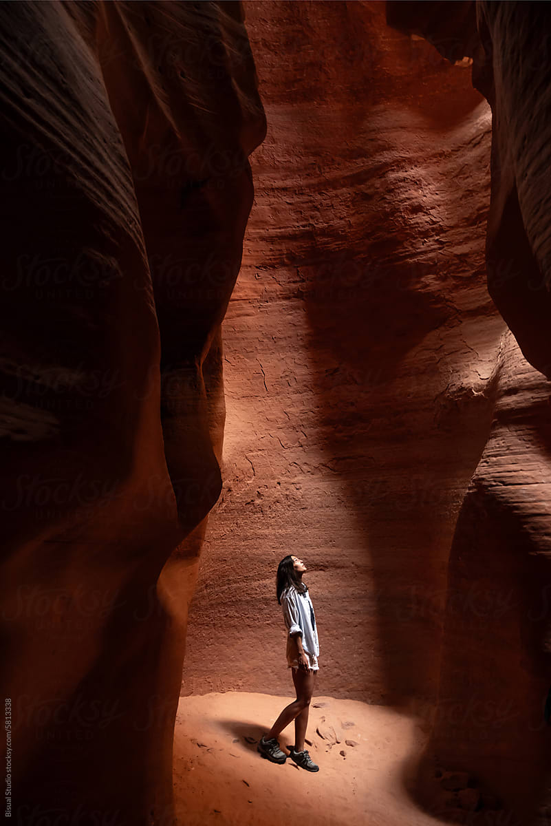 Woman looking up from the bottom of a narrow canyon in Arizona