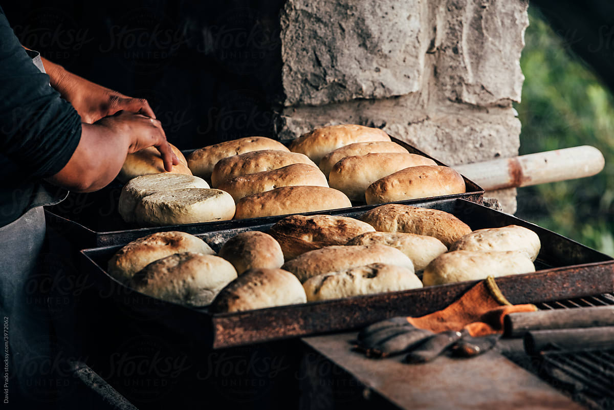 Faceless female baking bread in rustic bakehouse