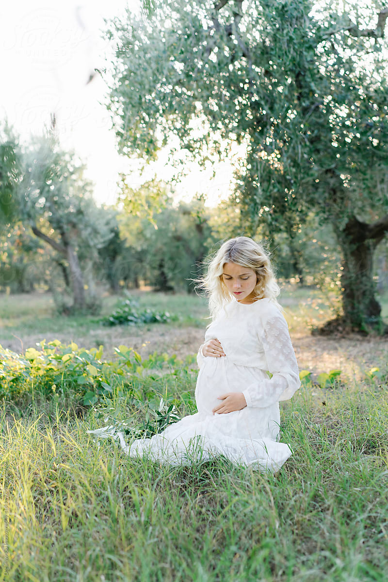 Pregnant woman relaxing in olive grove
