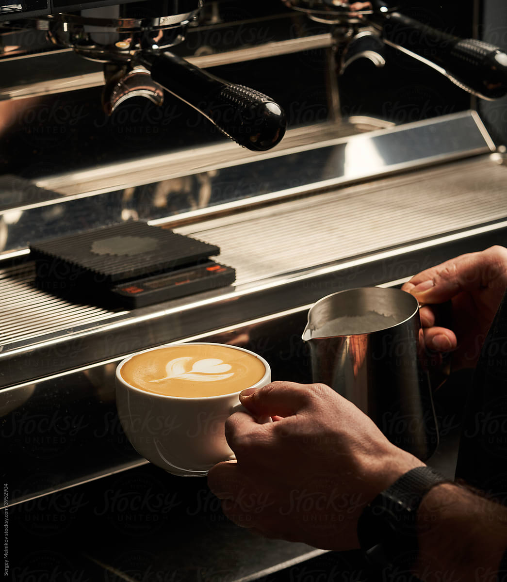 Crop barista preparing cappuccino in coffee shop