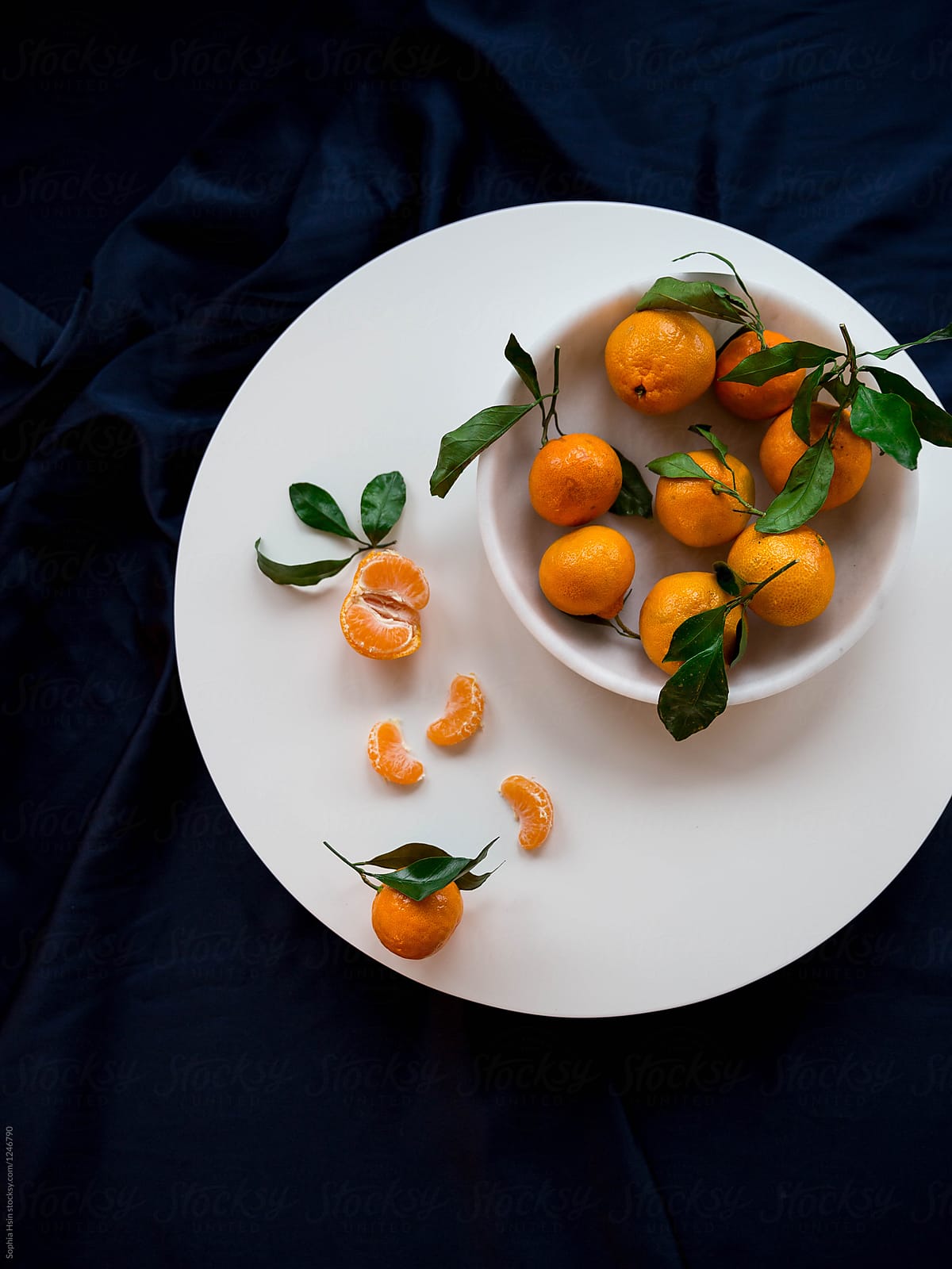 Satsumas in marble bowl on table with black background