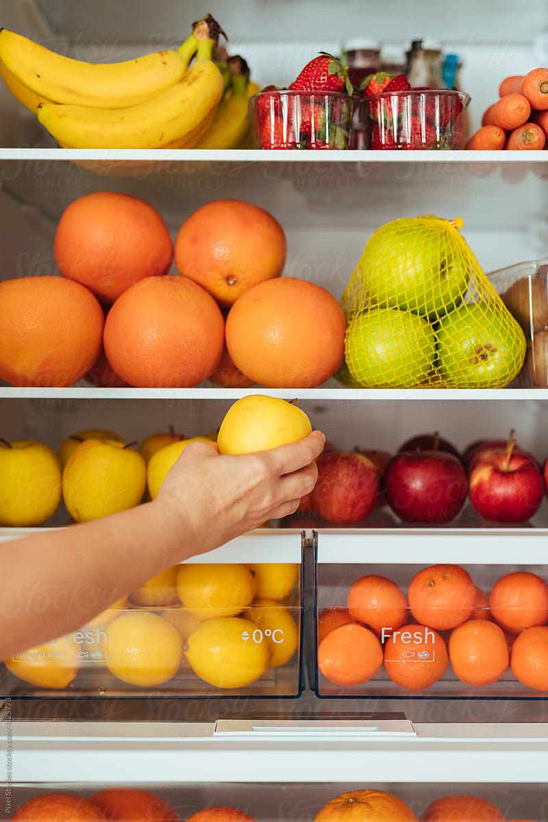 Healthy food concept: Grabbing apple from fridge