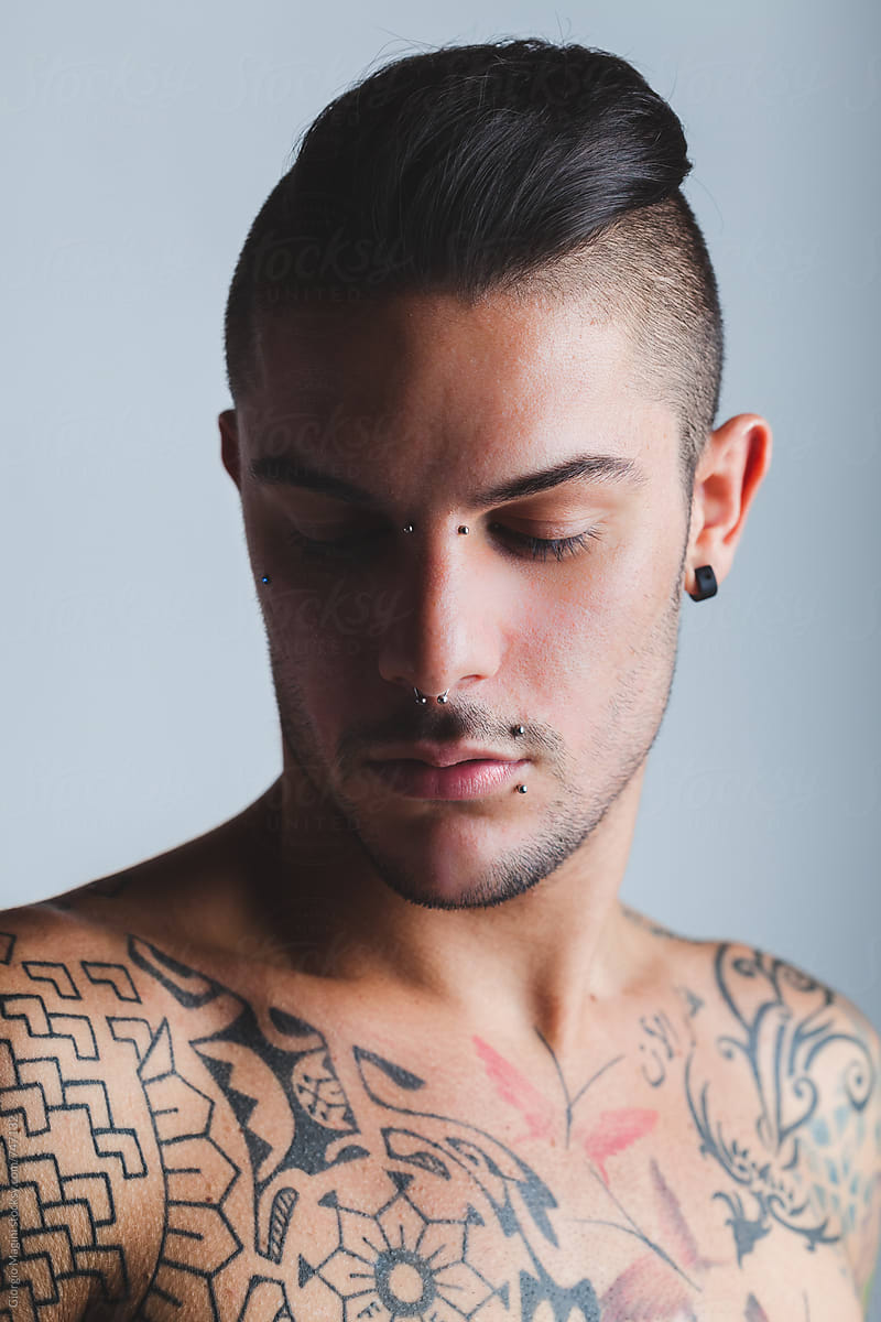 Sexy Young Man with Piercings and Tattoos, Studio Portrait