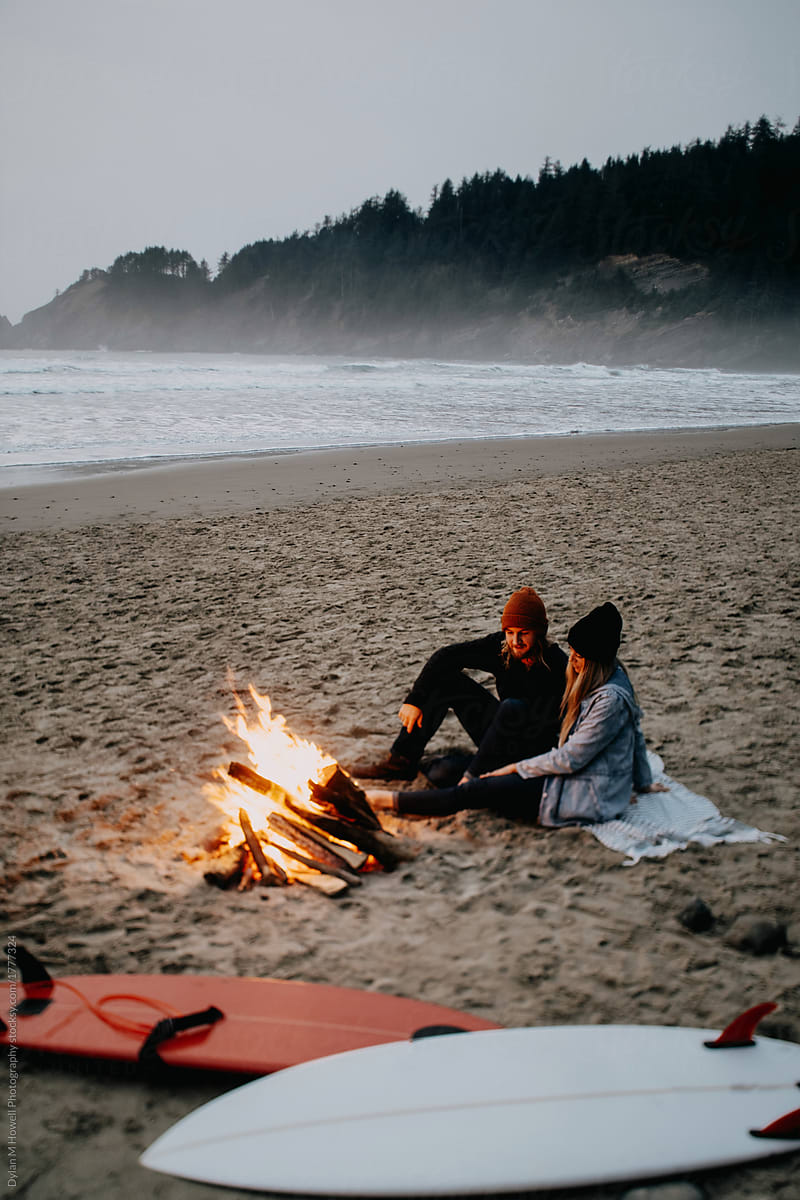 couple has a campfire after surfing