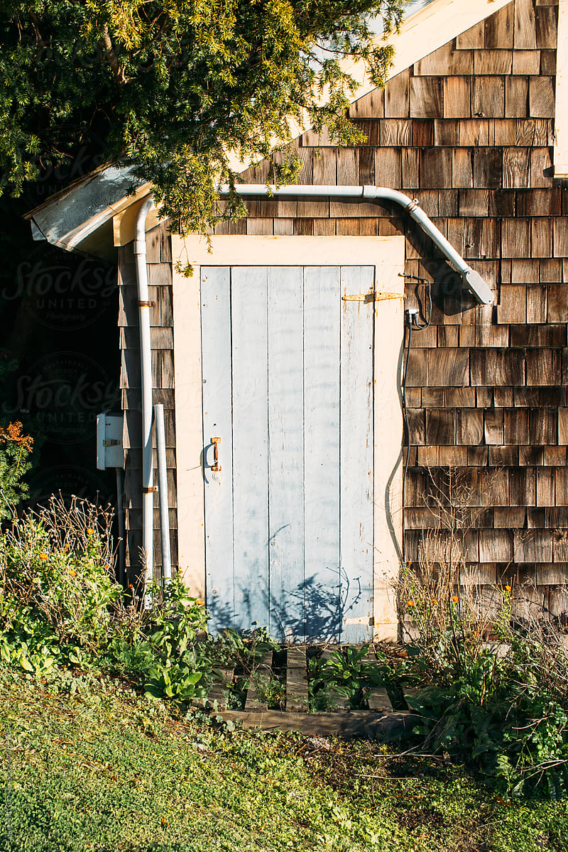 Light Blue Door In White Trim Frame Of Cedar Shingle Cabin