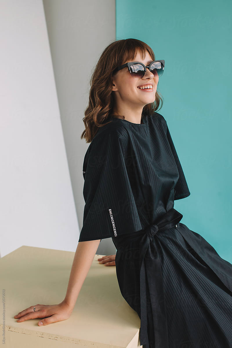 Cheerful woman in sunglasses studio portrait