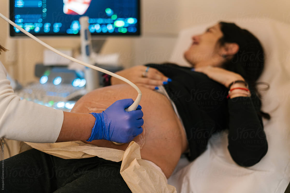 Happy pregnant woman and scanning doctor hand in lab