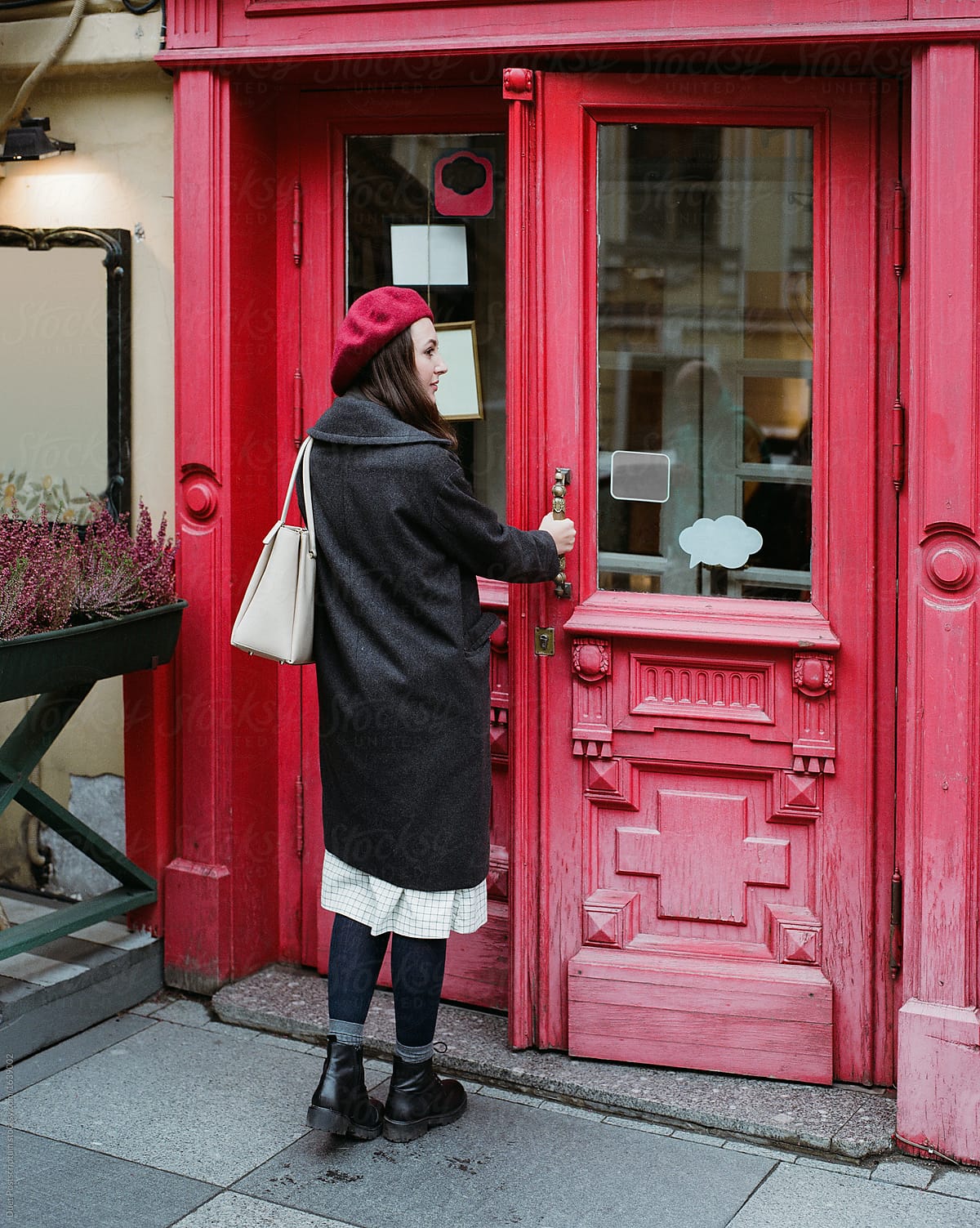 Woman entering place with red door