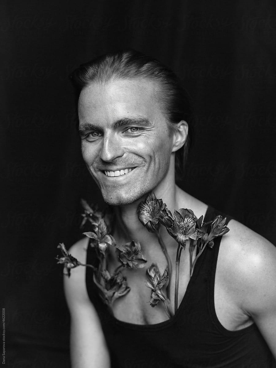 Black and white portrait of a man with Alstroemeria flowers